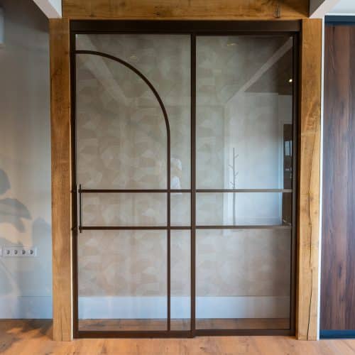 Aluminium schuifdeur in bronskleur met elegante boogvorm