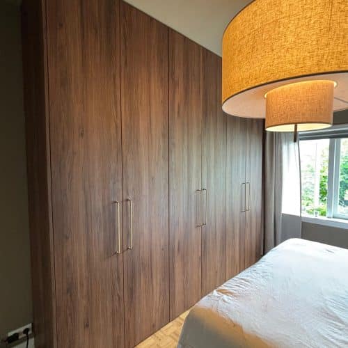 Strakke maatwerk kast met geïntegreerde lades en open vakken in moderne woonkamer